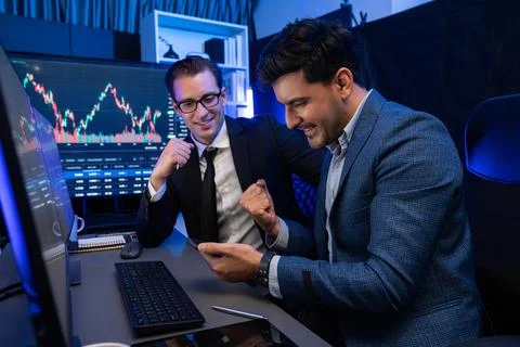 Traders comparing dynamic investment graph via phone and pc. Sellable. Stock Photos
