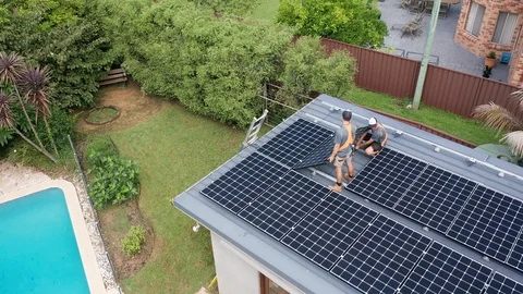 Trades men connecting and installing solar panels onto a flat roof Stock Footage 126304887