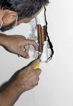 Tradesman fixing a copper pipe Stock Photos