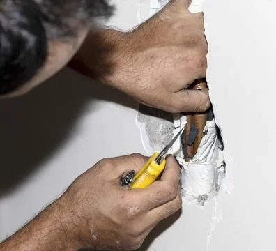 Tradesman fixing a copper pipe Stock Photos