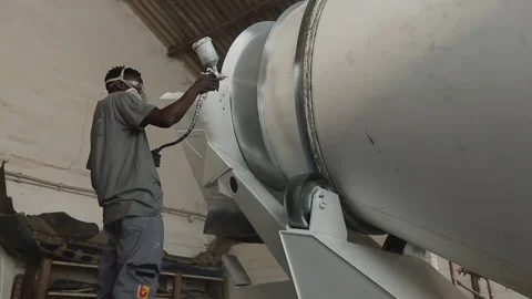 Tradesman spray paints the deck of a tip truck Stock Footage 322020576