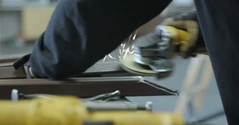 Tradesman uses angle grinder in metal shop Stock Footage 56864868