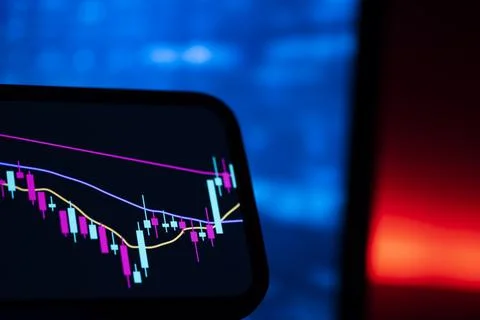 Trading app candlestick chart on a phone with blue and red neon light Stock Photos