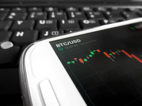 Trading bitcoins using a smartphone Stock Photos