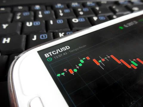 Trading bitcoins using a smartphone Stock Photos
