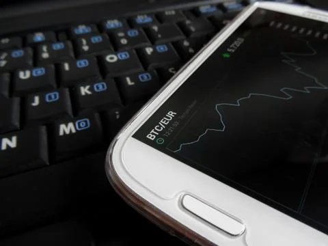Trading bitcoins using a smartphone Stock Photos