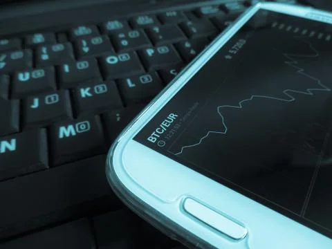 Trading bitcoins using a smartphone Stock Photos