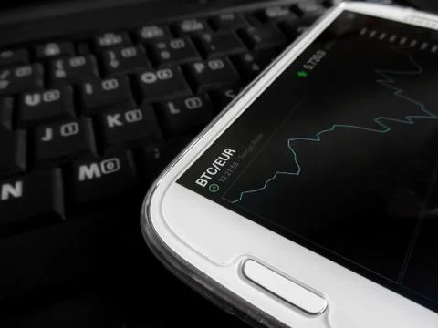 Trading bitcoins using a smartphone Stock Photos