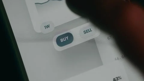 Trading interface with options to buy or sell financial assets, user taps the Stock Footage 333850730