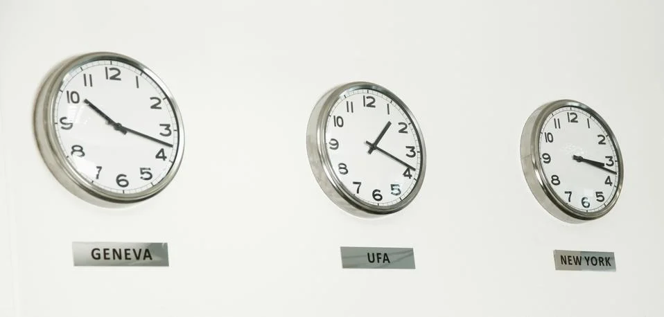 Trading international time wall clocks Geneva, Ufa, New York Stock Photos