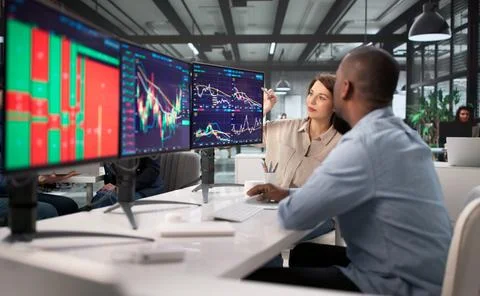 Trading Stocks With A Diverse Team Using Multiple Computer Monitors. African- Stock Photos