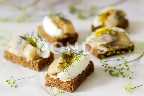 Tradition Danish open sandwich smorrebrod with herring, egg, mustard and dill Stock Photos