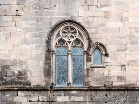 Traditional ancient gothic style window on stone wall Stock Photos
