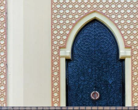 Traditional arabesque pattern on the wall, arched iron door Foto stock