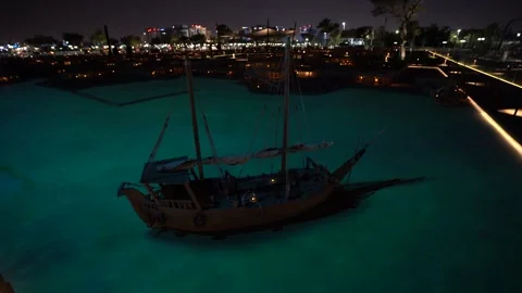 Traditional Arabic Dhow Boat Floating at Night with Turquoise Water Stock Footage 337044346