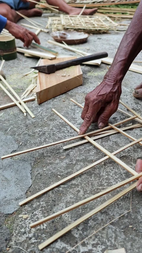 Traditional artisan hands weaving bamboo strips for craft work Stock Footage 346018136