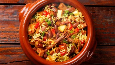 Traditional Baio de Dois served in a clay pot on a rustic wooden table Video stock 334354415