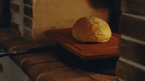 Traditional bakery worker chef placing bread on a tray in a traditional stone Stock Footage 279230359