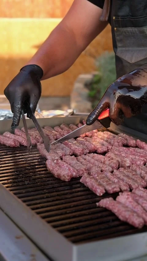 Traditional Balkan cevapi made from minced meat being grilled on a hot barbecue Stock Footage 346692825