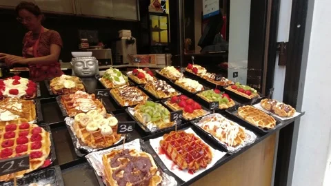 Traditional Belgian waffles with different toppings and vendor making more stree Stock Footage 211328278