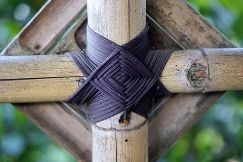 Traditional black rope binding forming a neat diamond pattern on a bamboo Stock Photos