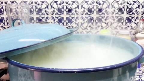 Traditional blue enamel pot with boiling paste cooking on Talavera tile stovetop Stock Footage 344456874