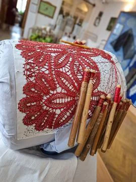 Traditional bobbin lace weaving process with red thread on a pillow using w.. Stock Photos