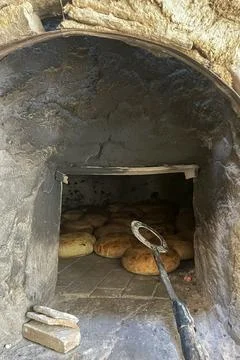 Traditional Bread Baking in Rustic Stone Oven. Stock Photos