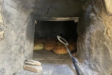 Traditional Bread Baking in Rustic Stone Oven. Stock Photos