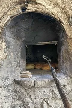 Traditional Bread Baking in Rustic Stone Oven. Stock Photos