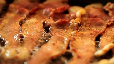 Traditional breakfast featuring fried bacon slices, comforting morning rituals. 스톡 동영상 334643183