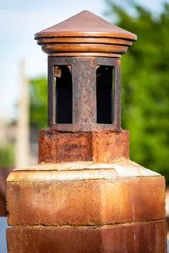 Traditional brick chimney stack situated on the side of a brick wall, with a tre Stock Photos