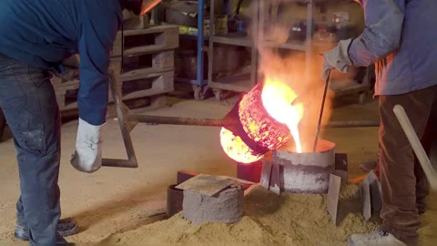 Traditional bronze casting process in bell foundry with molten metal pourin.. Stock Footage 308621672