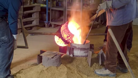 Traditional bronze casting process in bell foundry with molten metal pourin.. Stock Footage 308622102