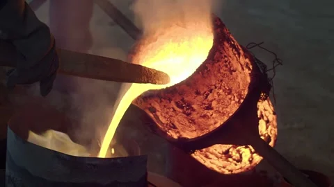 Traditional bronze casting process in bell foundry with molten metal pouring Stock Footage 308912699
