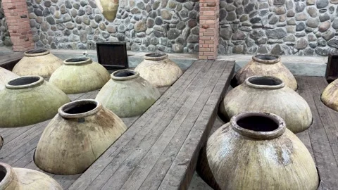 Traditional clay fermentation jars arranged in a rustic wooden room with stone Stock Footage 344345477