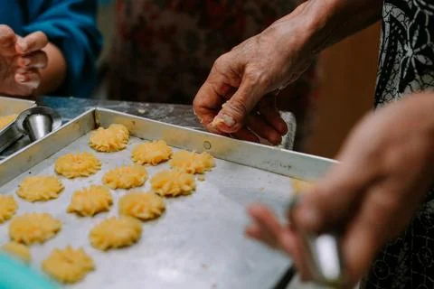 Traditional cookie making process, involving hands forming pastries on tray Stock Photos