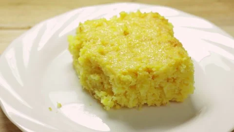 Traditional corn cake on a white ceramic plate being broken open with a fork Stock Footage 337083895