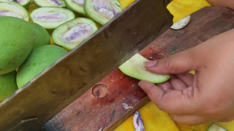 Traditional cutter slicing raw mango into multiple pickle pieces 스톡 동영상 336325323