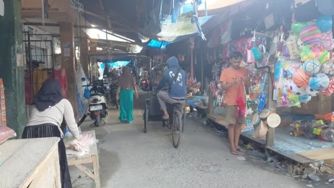 Traditional cycle rickshaw driving through narrow market alley 库存影片 330667340
