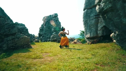 Traditional dancer performing between giant limestone rocks Video stock 280619366