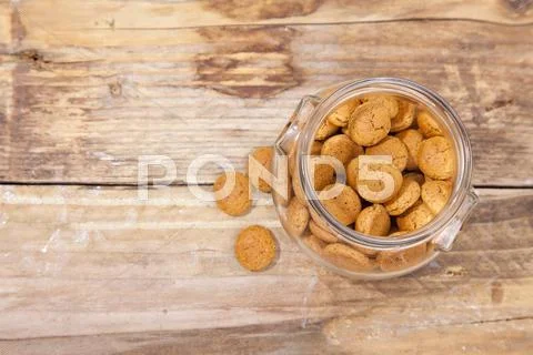 Traditional Dutch candy pepernoot in glass jar on wooden background Stock Photos