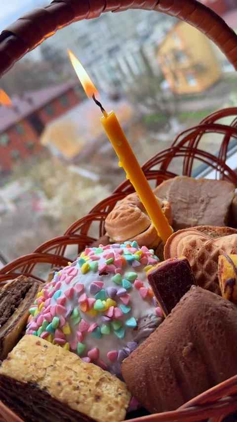 Traditional Easter basket with paska, eggs, meat and lit candle Stock Footage 334184740