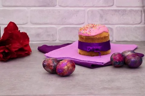 Traditional Easter cake and decorative multi-colored eggs on a gray backgroun Stock Photos