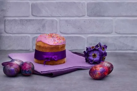 Traditional Easter cake and decorative multi-colored eggs on a gray backgroun Stock Photos
