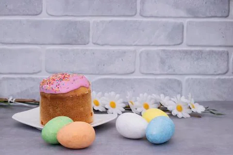 Traditional Easter cake and decorative multi-colored eggs on a gray backgroun Stock Photos
