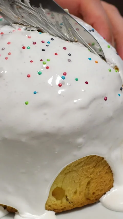 Traditional Easter cake with cut piece and colored eggs on light table. Candle 動画素材 306757983