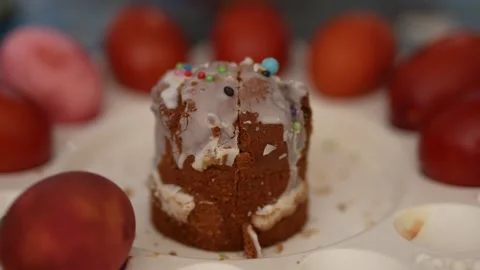 Traditional Easter cake with icing surrounded by colorful dyed eggs Stock Footage 332610832