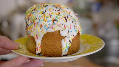 Traditional Easter Cake with White Icing and Sprinkles on Yellow Plate Stock Footage 339069326