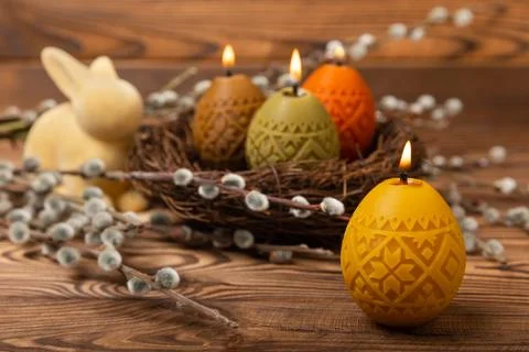 Traditional Easter decor. Burning soy candles in the shape of colorful eggs Stock Photos